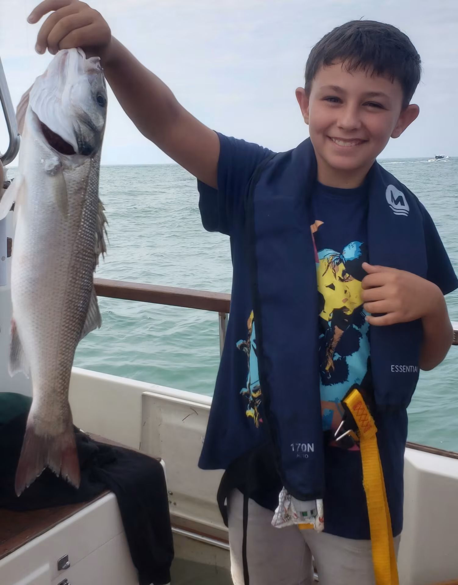 Enfant heureux pendant une sortie pêche en famille sur le Bassin d’Arcachon avec Arcapeche
